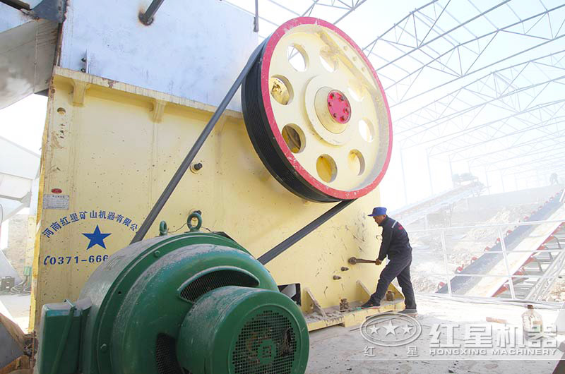 顎式破碎機(jī)生產(chǎn)現(xiàn)場(chǎng)，紅星工作人員正對(duì)設(shè)備進(jìn)行檢修
